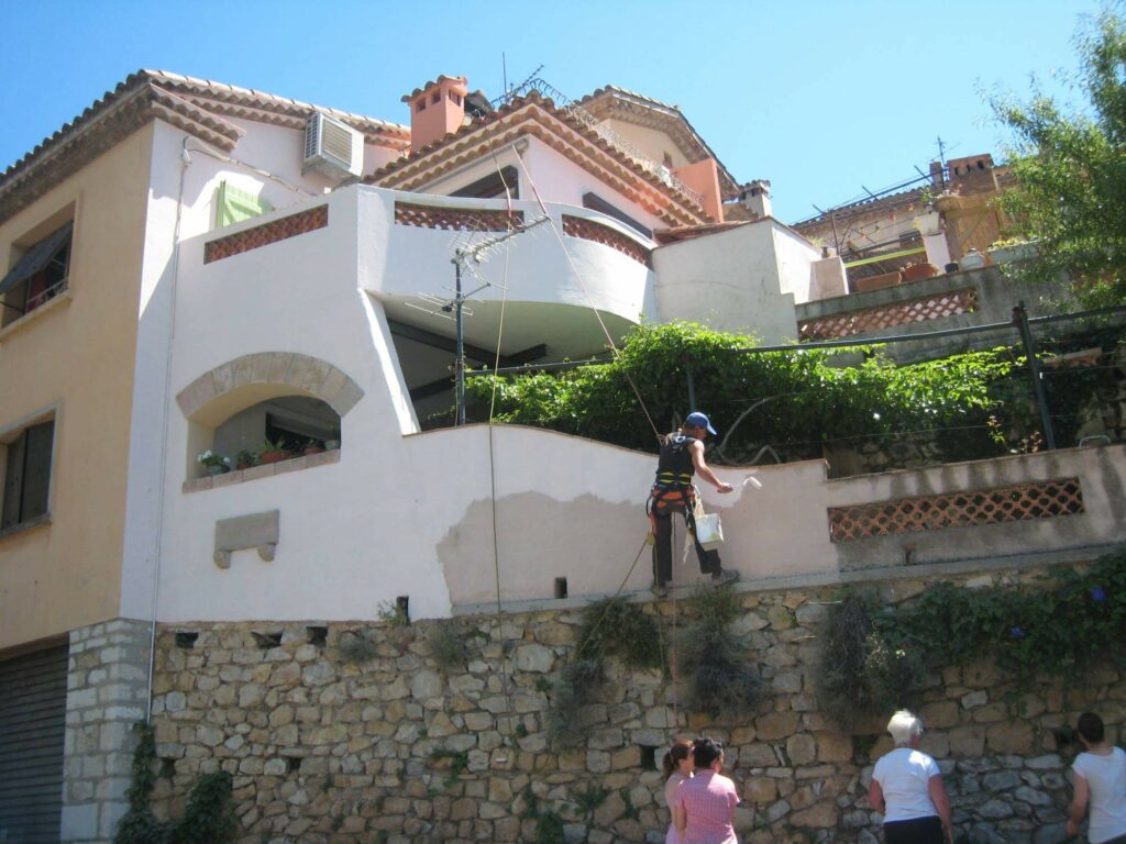 Techniciens traitant la façade d'une villa